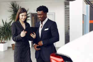 Car dealer and client reviewing a document together